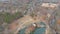 Aerial footage of a gorgeous blue lake surrounded by autumn colored trees and lush green trees and yellow winter grass