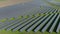 Aerial footage of hundreds solar modules or panels rows along green fields somewhere in Europe