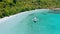 Aerial footage of island hopping tourist boat near tropical sandy beach in shallow turquoise blue Cadlao lagoon. El-Nido