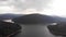 Aerial Footage of Large Lake  and mountains surrounded by Forest