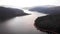 Aerial Footage of Large Lake  and mountains surrounded by Forest
