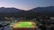 aerial footage of the Monrovia High School with a football field and a baseball field surrounded by homes, lush green trees