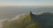 Aerial footage of ocean coast. Pointed mountain towering high above houses in urban boroughs. Cape Town, South Africa