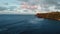 Aerial footage of ocean waves, shore with vegetation and houses, rainbow and clouds Kauai, Hawaii, USA