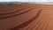 Aerial footage red soil farm plowing