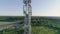 Aerial Footage servicing cellular antenna, worker dressed in uniform and helmet climbs the stair