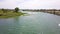 Aerial footage of the silky green waters of the Colorado River with people riding jet skis and lush green trees and plants