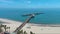 aerial footage of Stearns Wharf Pier with blue ocean water, boats and yachts sailing and people relaxing in the sand at West Beach