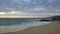 Aerial footage of a vast blue ocean water with waves rolling into the beach at Pirate Tower and people on the beach