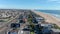 Aerial footage of vast miles of coastline at Sunset Beach with beachfront homes, ocean water and cars driving on the street