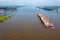 Aerial from a freighter full of containers cruising on the river Merwede near Gorinchem in the Netherlands in a flooded landscape