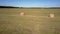 Aerial golden straw bales on field and drone shadow