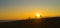 AERIAL: Golden sunbeams shine on friends downhill biking at picturesque sunset.