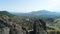 Aerial of great relief of rocks among the thick green forest growing down in the valley. Shot. Close up of mountain peak