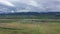 Aerial . Green fields and river. Mountains are visible on the horizon