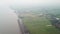 Aerial green paddy field beside coastal during mist day at Yan