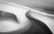 Aerial greyscale shot of a pathway on the beach near the waves of the ocean