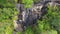 Aerial: Group of Young Tourists Resting at the Cascade Waterfall and Waving Their Hands in the Camera. Thailand.