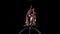 Aerial gymnasts performs a trick on the hoop metal construction. Black background. Slow motion