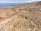 Aerial high angle view of the eroded landscape of Skazka Canyon in Kyrgyzstan with Lake Issyk-Kul in background