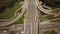 Aerial high drone flight over evening road traffic. Highway and overpass with cars and trucks, interchange, two-level road junctio