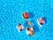 Aerial of hot pretty girls in bikini swimming in pool on floaties. Top view from above. Attractive fitted women in