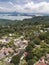 Aerial of houses along the Tagaytay caldera ridge with Taal volcano and lake further ahead in the background