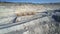 Aerial huge dump truck loaded with rock drives along road