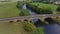 Aerial hyperlapse of cars crossing stone bridge over river