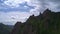 Aerial hyperlapse of clouds over the Takmak rock in the Russian Stolby Nature Reserve.