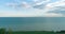 Aerial hyperlapse of sunset and clouds above sea coast. Timelapse drone fly near ocean bank. High speed horizontal