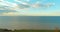 Aerial hyperlapse of sunset and clouds above sea coast. Timelapse drone fly near ocean bank. High speed horizontal