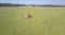 Aerial idyllic countryside with haystacks on field by forest