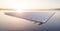 Aerial image of  floating solar power plant farm on calm lake  in beautifull sunset sunlight with misty forest landscape and cloud