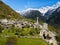 Aerial image of the Swiss mountain village Solio with the snow-capped Sciora range at the background