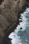 Aerial image of water hitting the black lavacoast of the new land of Capelinos volano after the 1957 volcanic eruptions