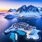 Aerial image of a winter sunset showing a blue snow capped a a a and a Hamnoy in the Norwegian Lofoten vistas in all