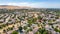 Aerial images over a community in Antioch, California with houses, cars, streets and trees. With a blue sky and room for text