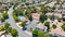 Aerial images over a community in Antioch, California with houses, cars, streets and trees. With a blue sky and room for text