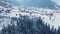 Aerial of inhabited locality in the mountains on winter. Mountain village buildings and houses on snowy hill slopes