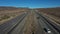 Aerial interstate freeway traffic Nevada California border fast pull 4K