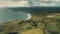 Aerial Ireland ocean gulf: countryside farms on rocks shore with stony beach. Cottages at greenery