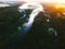 Aerial of a lake flowing through the trees in the forest.