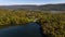 Aerial of a lake in upstate New York during the colorful fall foliage on a sunny day.