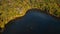 Aerial of a lake in upstate New York during the colorful fall foliage on a sunny day.