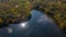 Aerial of a lake in upstate New York during the colorful fall foliage on a sunny day.