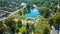 Aerial Lakeside Park pond with view of gardens and pools of water and distant houses