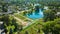 Aerial Lakeside Park ponds with fountains and view of gardens and pools of water and distant houses