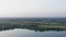 Aerial landscape green fields and forests on river shore. Drone view parasail flying over river water on skyline background