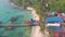 Aerial landscape of  Koh Touch village coast surrounded by palm trees with pier and Long Tail Boats in Koh Rong in Cambodia.